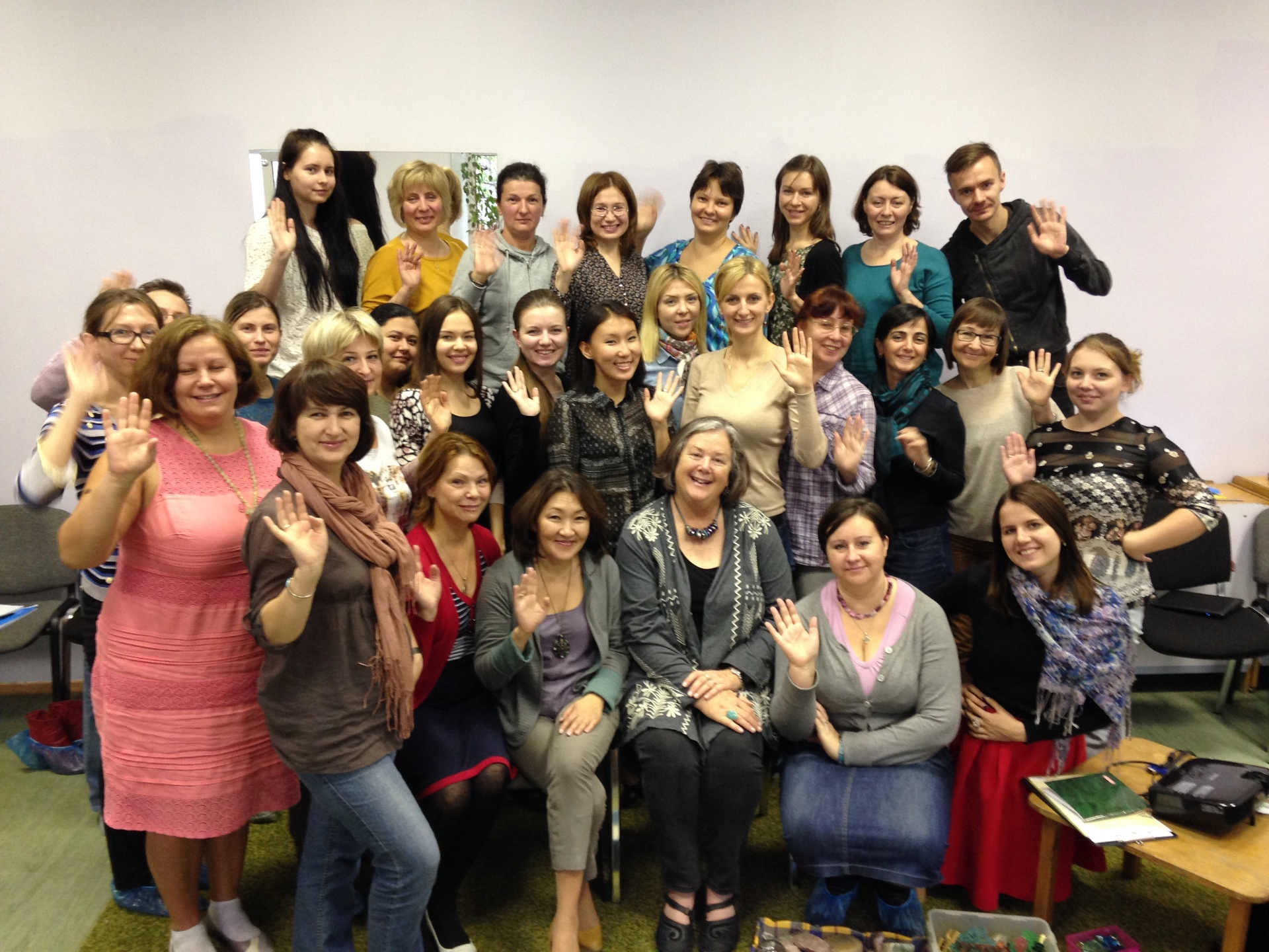 Sue with a large group of therapists waving at the close of an Oaklander training